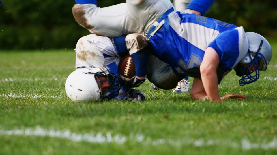 Football Player Tackling Another