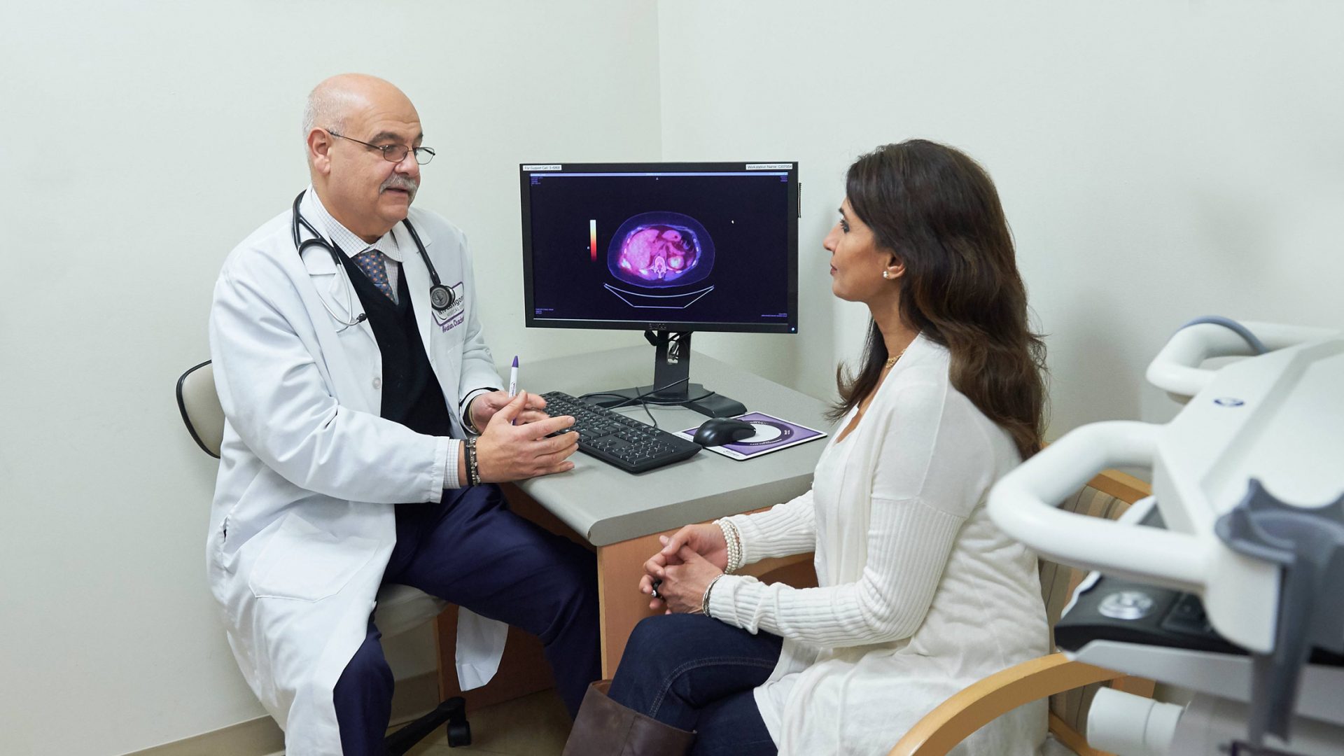 Dr. Abraham Chachoua Talking with Patient About Imaging Results on Computer