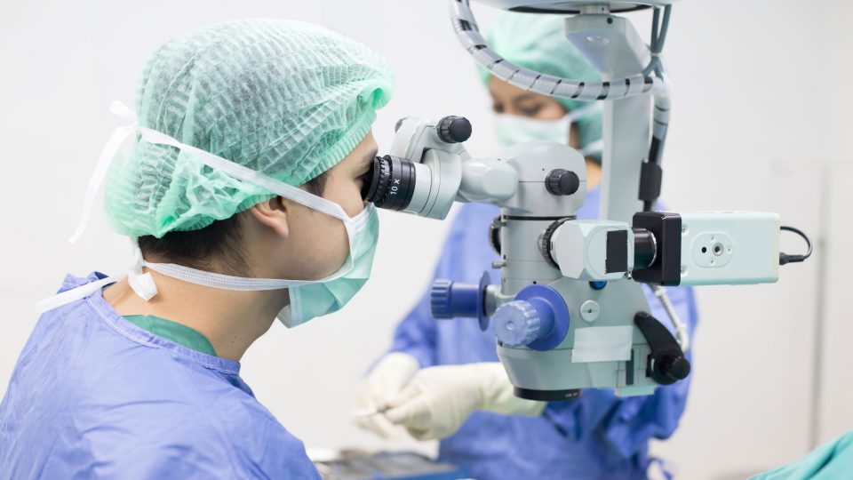 Doctor Using Microscope in Operating Room