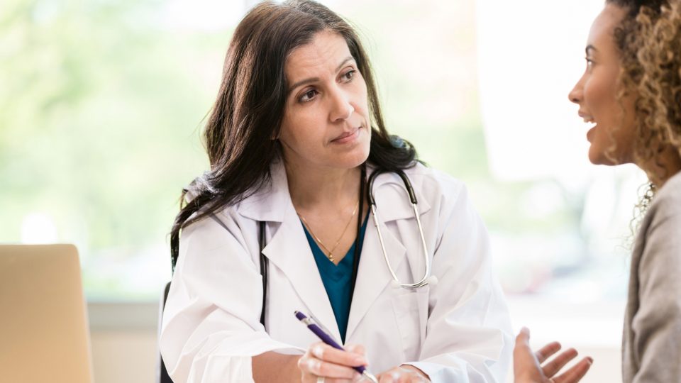 physician listening patiently to a young woman