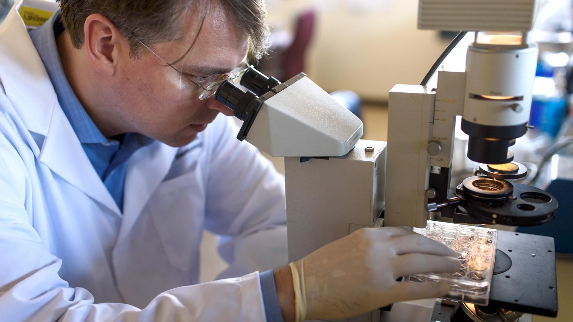 Dr. Johannes Nowatzky Examining Samples Through Microscope