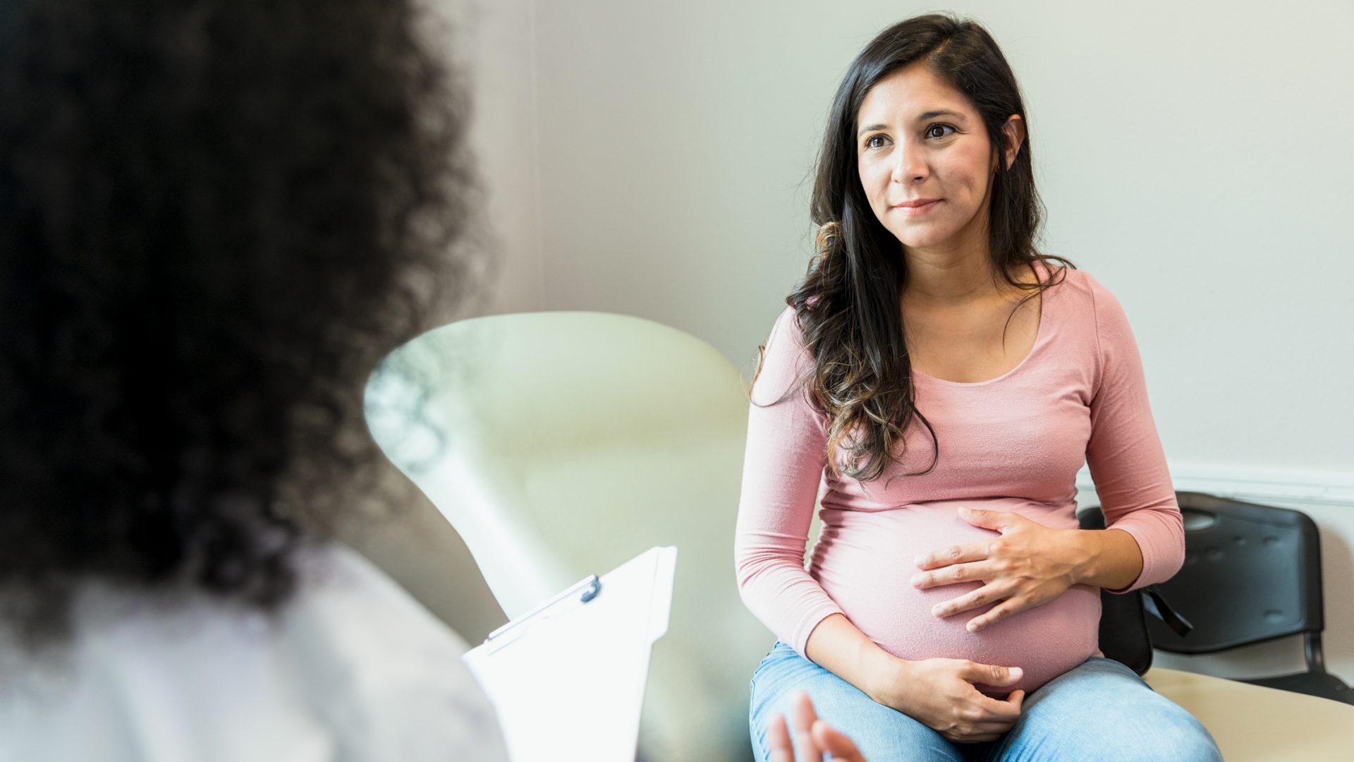 Pregnant Woman Speaking with Doctor in Exam Room
