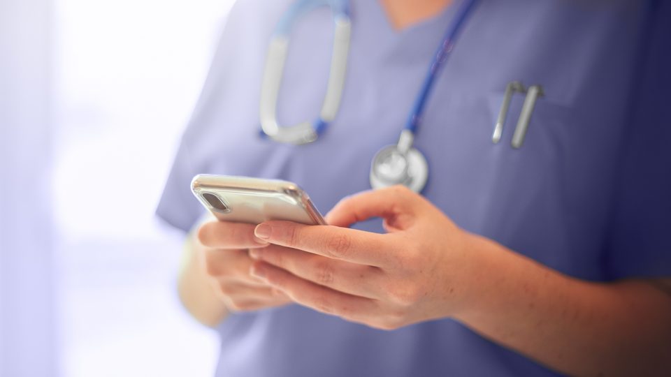 Close-up view of healthcare provider using mobile phone